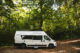 fourgon aménagé familial Peanuts stationné dans la nature pendant un road trip